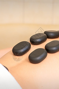 热石按摩疗程 白人年轻人在温泉沙龙后院做热石按摩呢中心岩石治疗疗法保健护理压力男性身体水疗图片