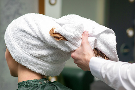 理发师在美容院洗完澡后 用毛巾包着年轻女子的湿头发治疗顾客服务发型女士店铺温泉女孩沙龙洗发水图片