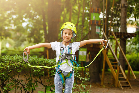 快乐的小女孩在一个绳子公园 在木头背景上乐趣冒险孩子风险童年操场运动危险行动绳索图片