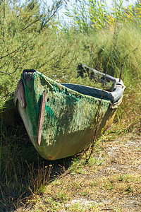 一艘废弃在河岸厚木船上的老木船环境绿船银行池塘支撑海岸村庄海岸线植物风化图片