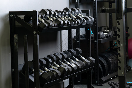 Dumbbell家的墙壁健身房模糊了装有坚固设备 从黑色运动衣中取出用于健健美健壮 重体力建筑图片