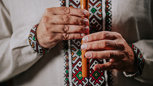 演奏木管乐器木笛的人的手-深色背景中的乌克兰 sopilka 民间音乐概念 乐器 传统刺绣衬衫的音乐家图片