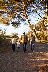 在逆境中共度难关 幸福家庭在清晨散步的后视镜头图片