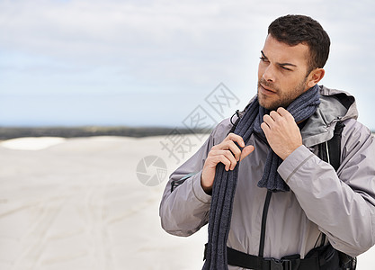这个气候对他来说没什么意义 一个年轻的男性徒步旅行者沿着沙丘行走图片