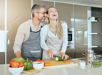 夫妻俩在厨房里一起在家里做饭 玩得开心 有说有笑 中年男女在家里切健康的蔬菜和做饭 微笑 快乐和爱人图片