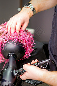发型师在美容院用烘发机吹湿定制粉色头发制造发型吹风机工作治疗客户职业护理造型顾客女性冰壶图片