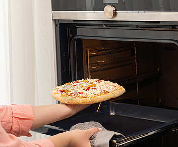 用传统的方式在家里烤炉里烤比萨饼图片