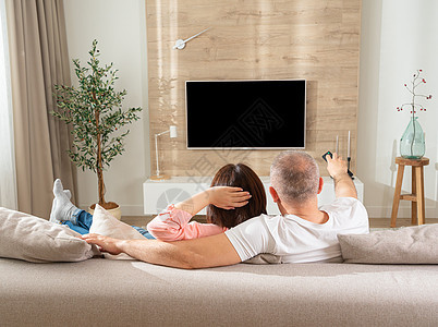 在电视前的白人男女 躺在客厅沙发上的沙发上图片