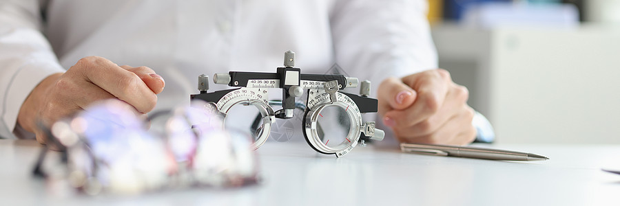 眼科专家近距离闭合医生眼科医生的桌子上 用眼镜检查视力医师配镜师屈光度药品验光诊所病人散光治疗眼睛背景图片
