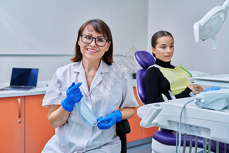 女性牙医的肖像 女病人坐在牙科椅上的女病人面具访问药品矫正椅子女孩考试保健诊所卫生图片
