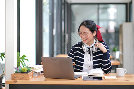 学生在室内笔记本电脑上学习  教育课程或培训 研讨会 在线教育概念 带现代笔记本电脑和耳机的亚洲女性在家学习青少年学校视频电话大图片