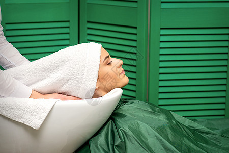 在美发厅洗头后 发型师用白毛巾包着一名年轻的天主教女性的头发治疗美容师发型设计温泉女士发型洗涤工作室理发客户图片