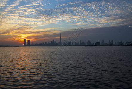 迪拜市上空的戏剧性日落 阿联酋外门建筑物房地产建造建筑学旅行港口天气景观城市地平线图片