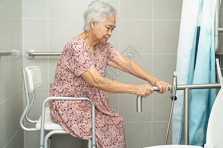 亚洲老年或老年老妇人病人在护理医院病房使用厕所浴室手柄安全 健康强大的医疗理念减值酒店卫生间洗手间金属座位苗圃洗澡扶手照片图片