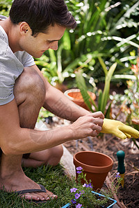 替他的花园捐钱 一个英俊的年轻人 在户外园艺图片