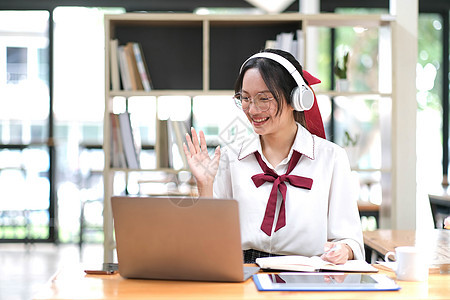 亚洲女学生在线学习班学习在线视频通话 zoom 老师 快乐的亚洲女孩用电脑笔记本电脑在线学习英语学校人士教育房间家庭电话耳机商务图片
