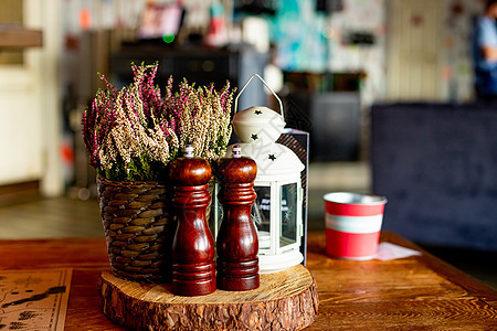 咖啡馆里的木制传统盐和胡椒瓶 有选择的焦点 乡村风格的舒适室内静物细节 木制香料瓶 磨坊 餐厅餐桌布置的一部分 石南花装饰图片