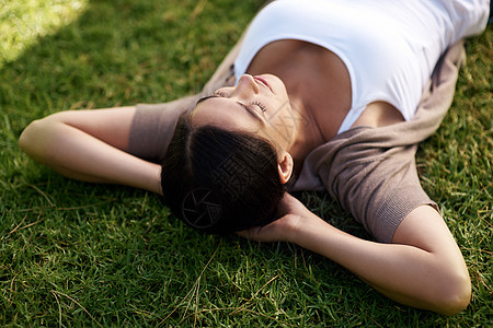 一天放假 一个年轻女人躺在草地上的高角度镜头图片