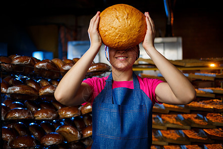 在面包店烘烤的阶段 在面包店货架的背景下 一个手里拿着面包的面包师女孩的画像 面包师的手用面包 工业面包生产男人工作室糕点女性工图片