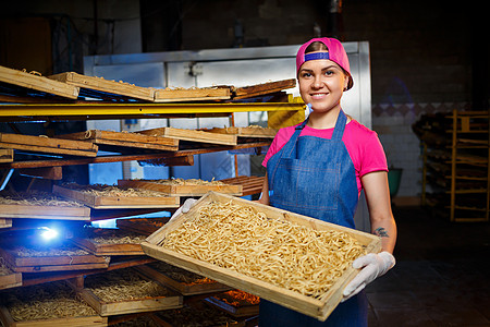 通心粉工厂 意大利面生产 生意大利面 拿着一盒意大利面的工人 女孩在意大利面的生产中工作工业面条美食就业贸易劳动者农产品加工机械图片