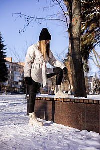穿着白色夹克和白皮靴的年轻美女 在雪地公园走来走去衣服毛衣幸福森林季节女孩长廊微笑时尚天气图片