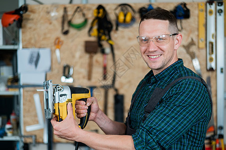一名男子在车间用电锯锯木头的肖像锯末拼图作坊材料木工机器手工职场工具工匠图片