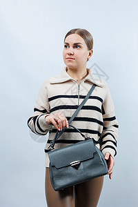 白色背景的灰色皮袋女人 时髦的离合包 近身垂直照片购物学校身体互联网电脑蓝色牛仔布配件女性商业图片