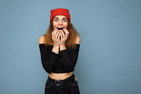 你是认真的吗？一张美丽迷人的特写照片震惊了惊奇的年轻女子 她张着嘴 穿着休闲服 在色彩缤纷的背景中与空旷的空间隔开图片