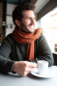 快乐男人的垂直肖像 在咖啡店喝早间咖啡 望着窗外图片