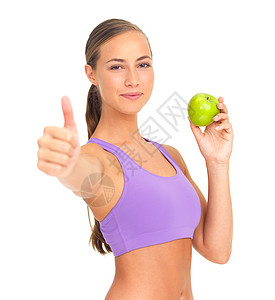 对健康的生活方式赞不绝口 一个运动的年轻女人拿着一个苹果 给你竖起大拇指的工作室肖像图片