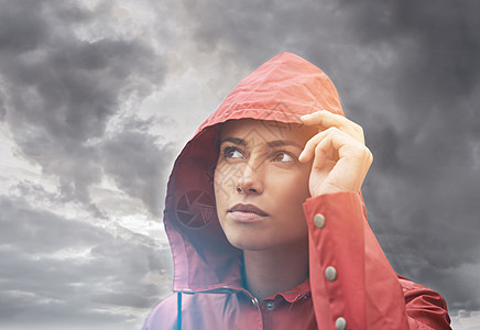 这些天空看起来不祥 一个年轻女子站在雨中 面对灰色的天空图片