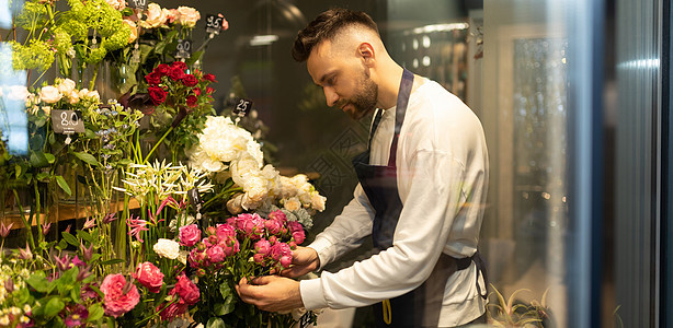 一位经验丰富的男性花店男花商 在花丛店里检查冰箱里的花图片