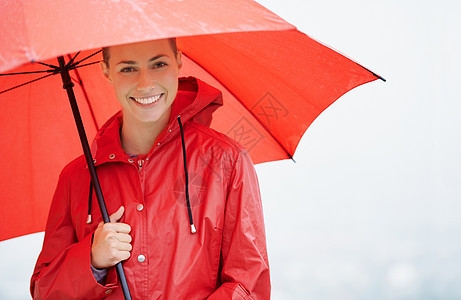 感到安全和受到保护 一位美丽的年轻女子撑着红伞站在外面图片