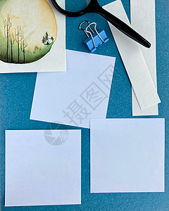 蓝色背景空纸提醒或用抽水彩色手工放大镜和剪贴板做列表时的印花卡模型图片