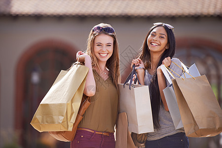 两位有魅力的年轻女子在经过一天的零售治疗后 带着购物袋去逛街了图片
