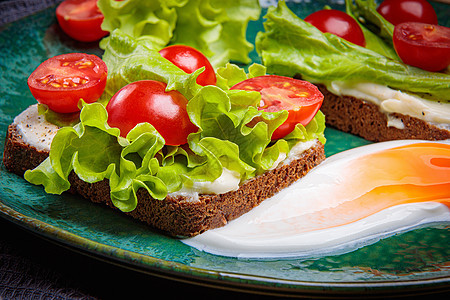 黑面包三明治 加融化的奶酪沙拉和西红柿 在绿色盘子上叶子乡村面包营养早餐食物粮食小吃蔬菜团体图片
