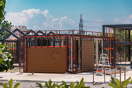 新建建筑的金属框架 建造一栋新的小房子工程师钢结构桁架材料工程蓝色制造业工地房子天空图片