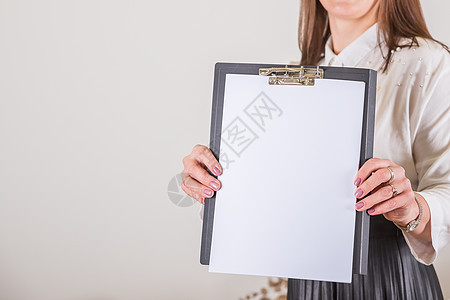 女人拿着一张空白的纸剪贴板 在女性手中的白纸海报 平面设计师作品集的空白模板 在商业 博客 教育方面制定计划笔记广告女士训练经理图片