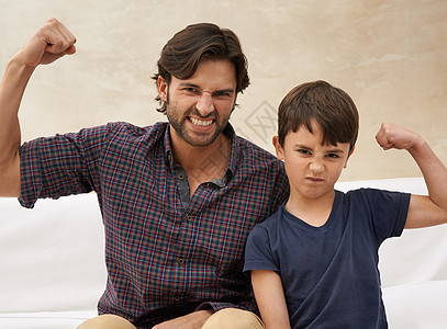 做肌肉和刻薄的面孔 父亲和儿子一起享受好时光图片