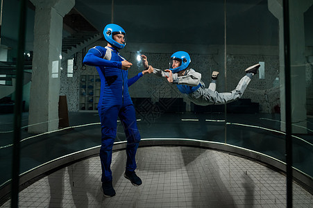 男人教女人如何在风隧道飞翔 自由坠落模拟器飞机跳跃吸引力航空悬浮运动空气气氛管子天空图片