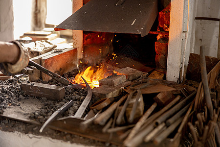 铁匠在金属产品的生产过程中 在锻造中手工制作 工匠在火中加热金属 金属工业 古老的职业作坊工作金工男人手工业铁工罢工铁匠铺工人工图片