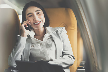 亚洲商业妇女与客户交谈 然后去开会和处理大型项目 工作与旅行概念成人技术笔记本运输男人航空公司机场女性窗户空气图片
