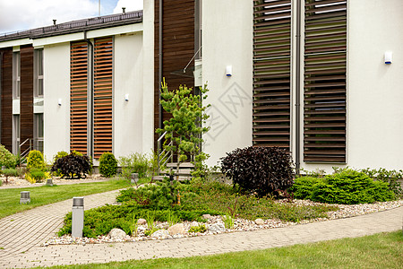 现代住宅前院前的各种植物和石头 景观设计 美丽的花园 带私人庭院的现代都市生活住宅 绿色户外设施 草坪 花园护理建筑物建筑学树篱图片