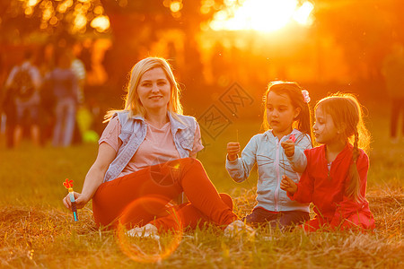 美丽的年轻母亲和女儿在田野上玩得开心投标晴天父母女士小麦场地女性乐趣夫妻公园图片