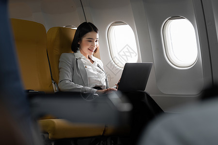基金投资女性坐在飞机上 在与客户会面之前检查项目 工作和旅行概念图片
