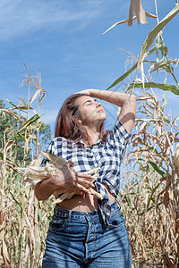 玉米作物田中富饶的女天主教女艺人农田女士生长环境农民成人检查女性收成麦田图片