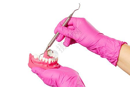 牙科医生的手与人下巴和牙齿修复仪器的布局刮匙金属医疗外科卫生工具手套牙科治愈药品图片