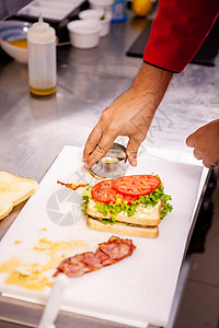 厨师做三明治 配有新鲜成分火腿木板木头盘子餐厅火鸡食物小吃土豆午餐图片