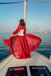 夏日在游艇上穿着红色礼服的中年女子 有吸引力的中年妇女 豪华暑假冒险 户外活动运输海洋女士方向盘蓝色旅行女性帆船双体微笑图片