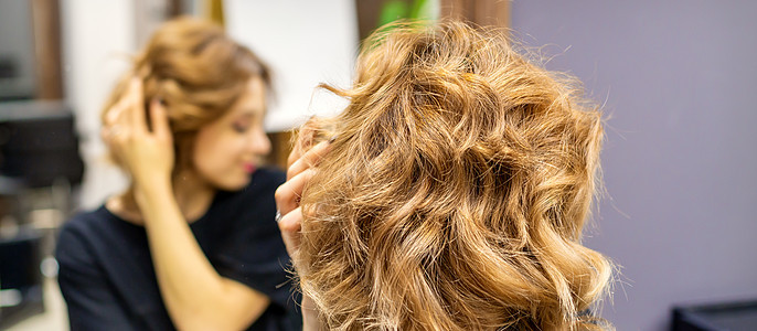 年轻女人在理发店的美容镜前 检查她新的棕褐色新发型女孩美容师幸福洗发水女性刷子镜子化妆品工作成人图片